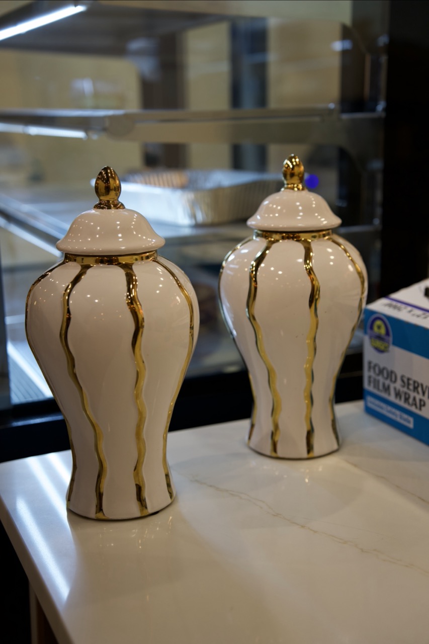 White-and-gold heritage jars on the marble counter