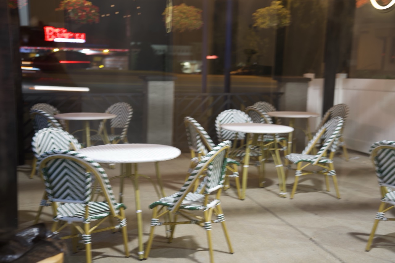 Bistro tables on the Qahwah Drip patio at night