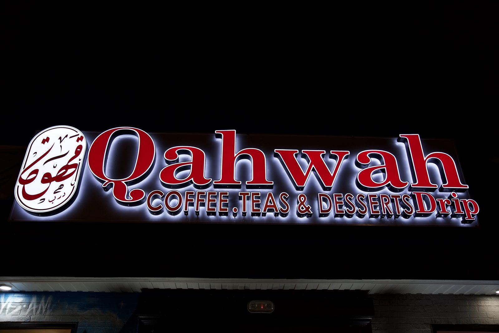 The illuminated Qahwah Drip storefront sign at night
